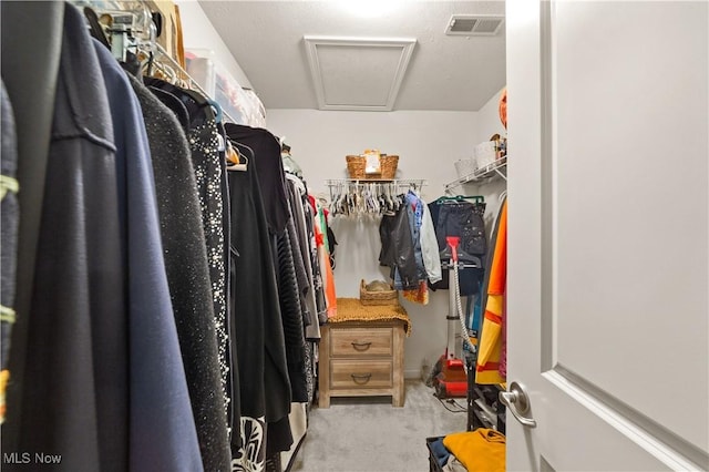 spacious closet featuring attic access, carpet flooring, and visible vents