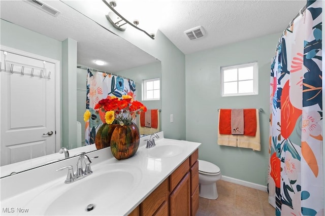 bathroom featuring toilet, a sink, and visible vents