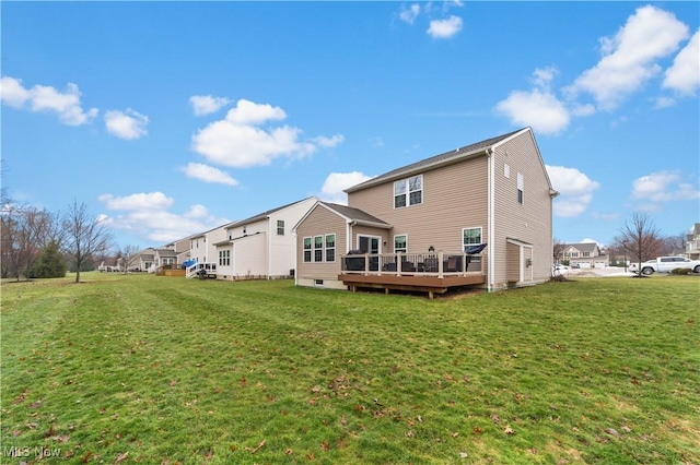 rear view of property featuring a deck and a yard