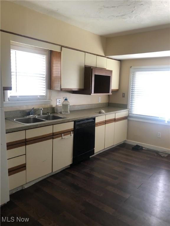 kitchen with dark wood-style floors, black dishwasher, white cabinetry, and a sink