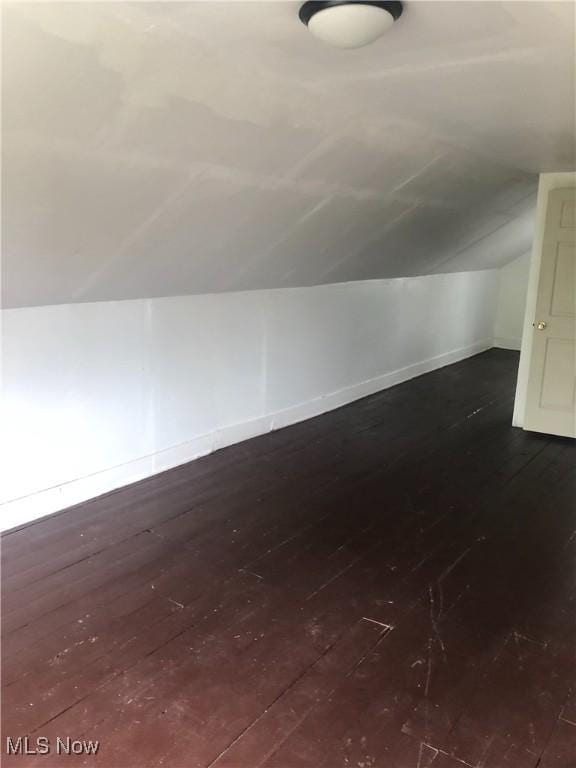 bonus room featuring lofted ceiling, wood-type flooring, and baseboards