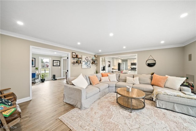 living room with light wood finished floors, baseboards, ornamental molding, and recessed lighting