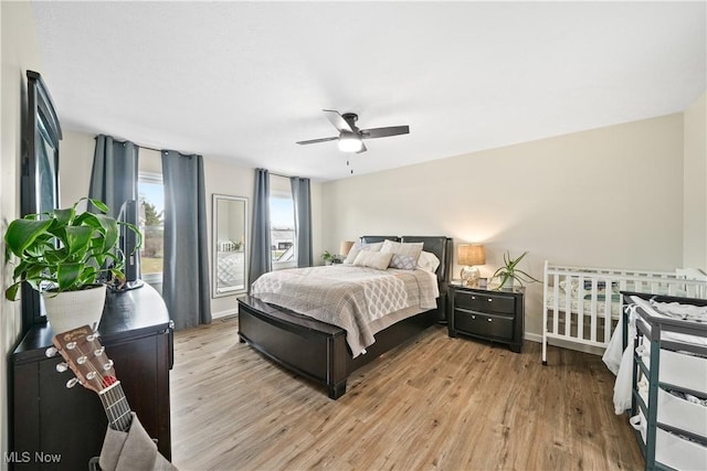 bedroom with baseboards, ceiling fan, and light wood finished floors