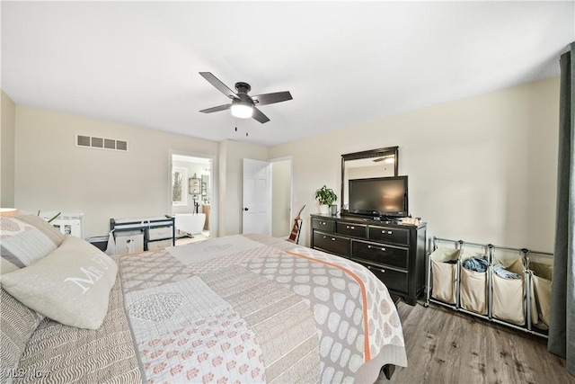 bedroom featuring ceiling fan, wood finished floors, and visible vents