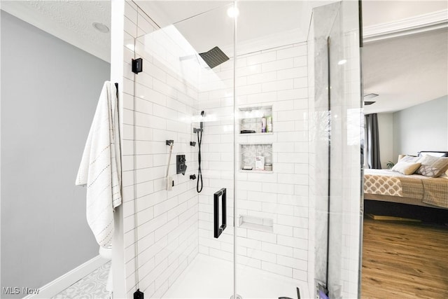 bathroom featuring baseboards, a shower stall, ensuite bath, and wood finished floors