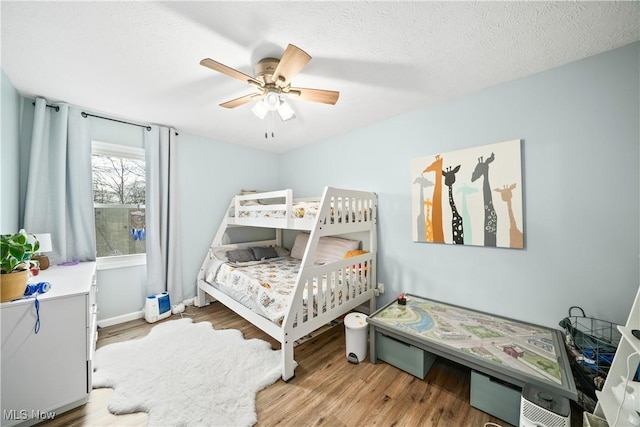 bedroom featuring a textured ceiling, ceiling fan, and wood finished floors