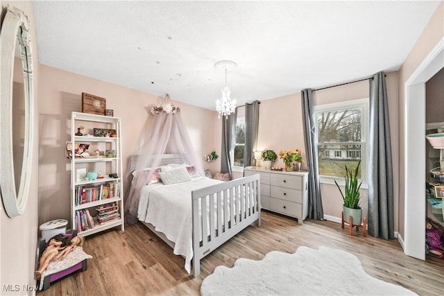 bedroom featuring wood finished floors and a notable chandelier