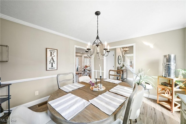 dining room featuring a notable chandelier, crown molding, stairway, light wood-style floors, and baseboards