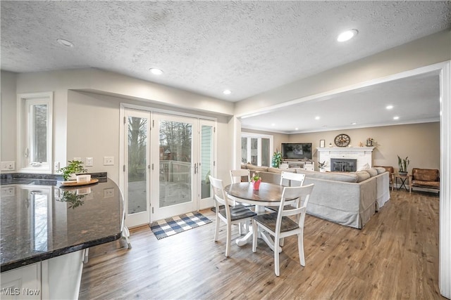 dining room with light wood finished floors, a fireplace, and recessed lighting