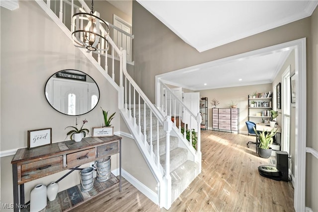 stairs featuring baseboards, crown molding, a chandelier, and wood finished floors