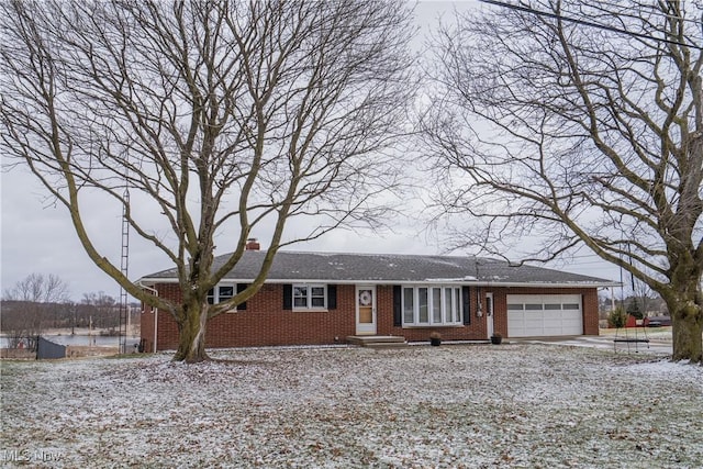 ranch-style home featuring a garage, brick siding, driveway, and a chimney