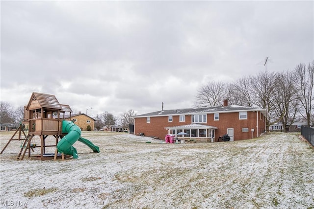 exterior space with brick siding, a chimney, and a playground