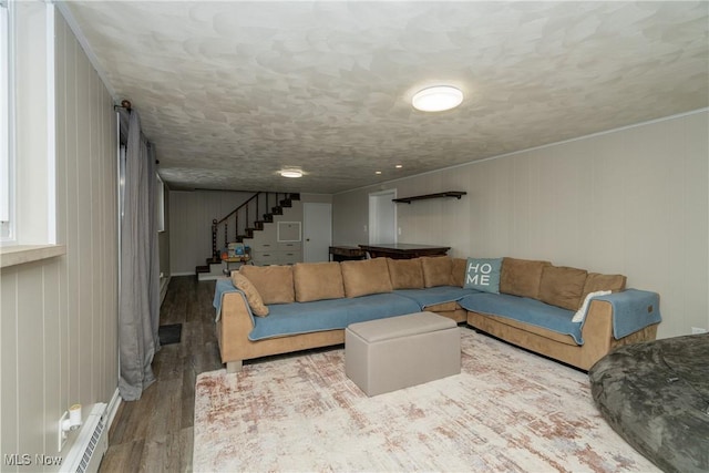 living area featuring a textured ceiling, stairs, and wood finished floors