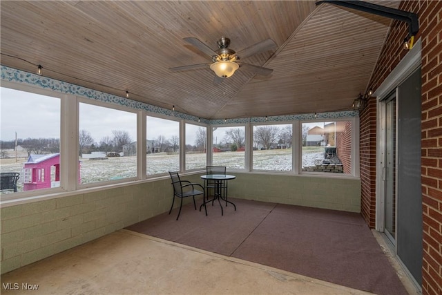 unfurnished sunroom with wood ceiling, vaulted ceiling, and a ceiling fan