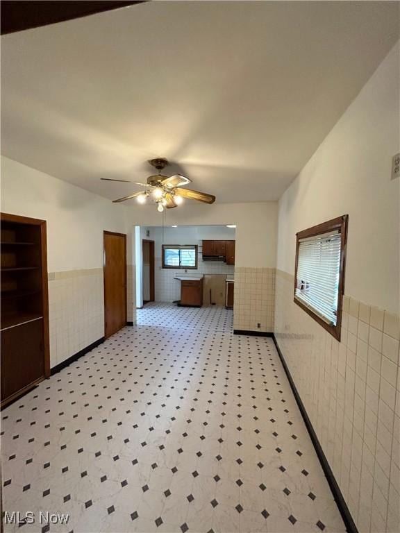 interior space featuring a ceiling fan and wainscoting