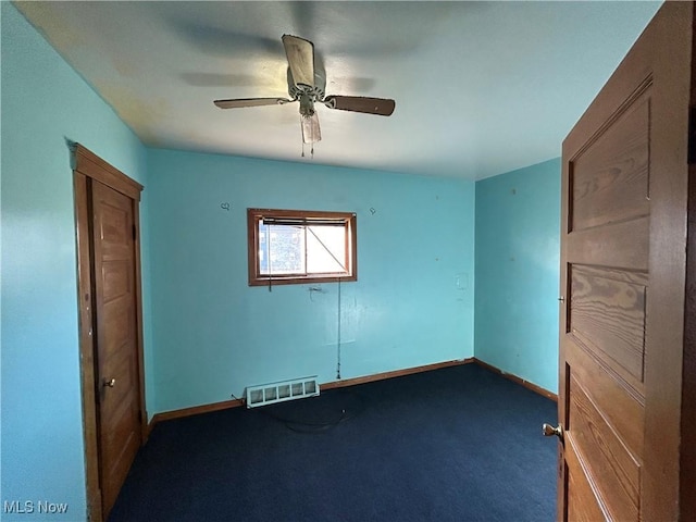 empty room with carpet, visible vents, ceiling fan, and baseboards