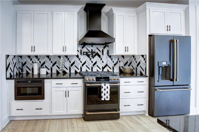 kitchen featuring stainless steel appliances, wall chimney exhaust hood, dark countertops, and white cabinets