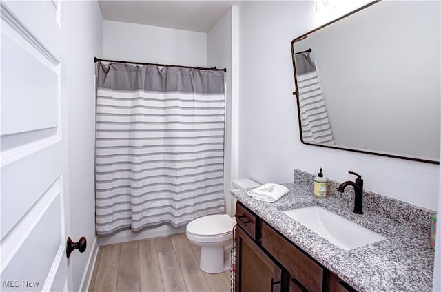 full bathroom with vanity, shower / bath combination with curtain, wood finished floors, and toilet