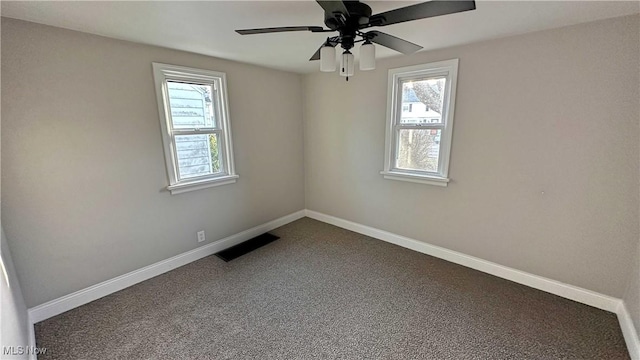 spare room featuring plenty of natural light, visible vents, and baseboards