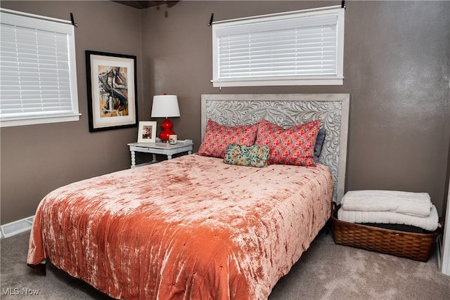 carpeted bedroom featuring visible vents