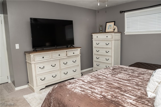 bedroom featuring light carpet and baseboards