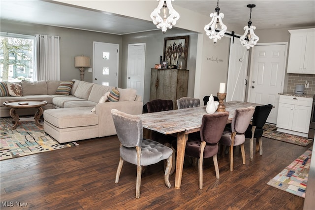 dining space featuring a barn door and dark wood-style flooring