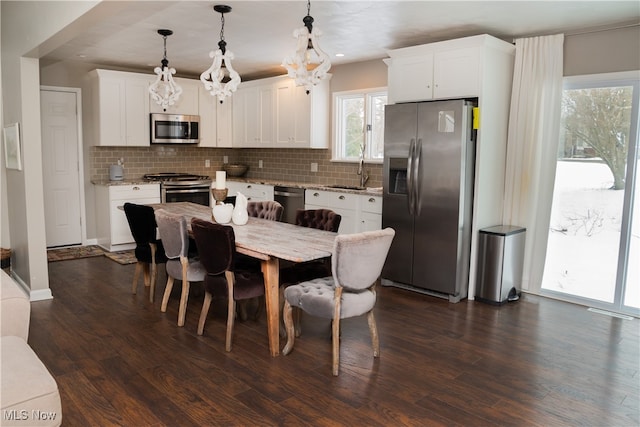 kitchen with stainless steel appliances, tasteful backsplash, dark wood-type flooring, white cabinetry, and a sink