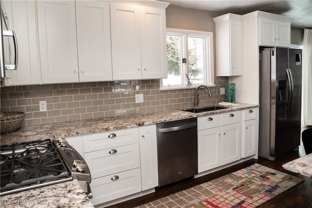 kitchen featuring tasteful backsplash, appliances with stainless steel finishes, white cabinets, and a sink