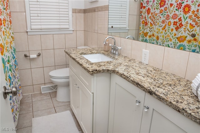 full bathroom with tile patterned flooring, toilet, visible vents, vanity, and tile walls