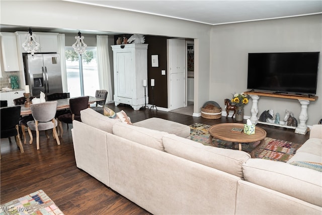 living area featuring a chandelier and dark wood-style flooring