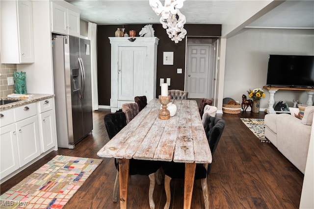 dining area with baseboards, dark wood finished floors, and a notable chandelier