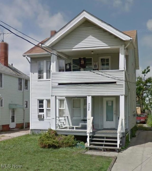 view of front of home featuring a porch, a front yard, cooling unit, and a balcony