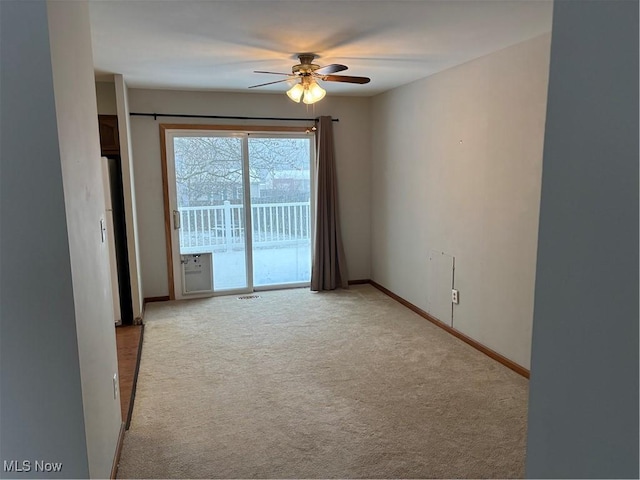 unfurnished room featuring a ceiling fan, light carpet, and baseboards