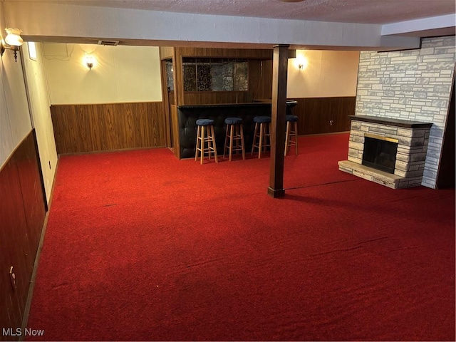 finished below grade area with wainscoting, wooden walls, and a bar