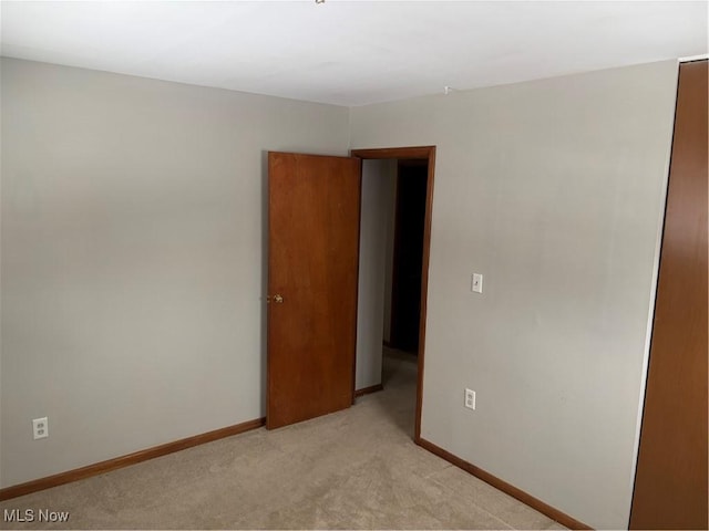 empty room with light colored carpet and baseboards