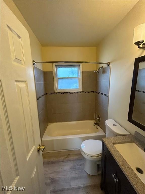 bathroom featuring vanity, wood finished floors, shower / tub combination, and toilet