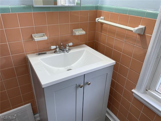 bathroom featuring visible vents, tile walls, and vanity