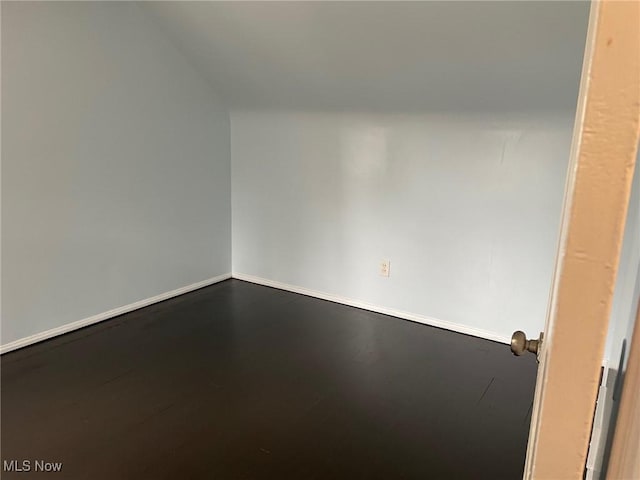 unfurnished room with baseboards and wood finished floors