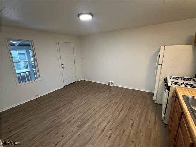 kitchen featuring visible vents, dark wood finished floors, baseboards, and white gas range oven