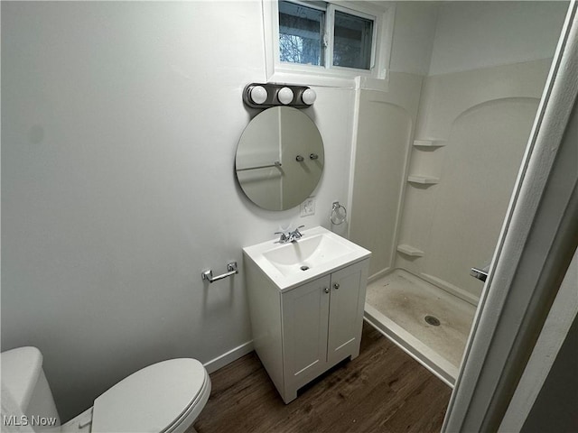 full bathroom with toilet, wood finished floors, vanity, baseboards, and a shower stall