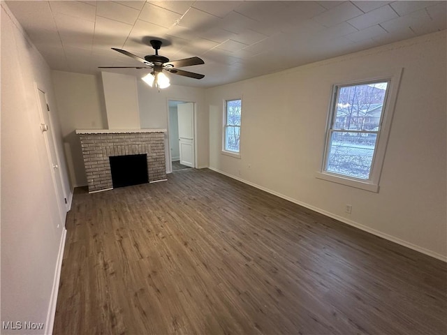 unfurnished living room featuring ceiling fan, dark wood-style flooring, a fireplace, and baseboards