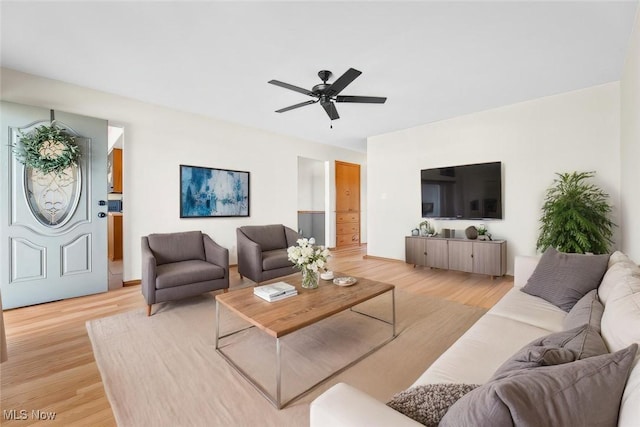 living area with light wood-type flooring and a ceiling fan