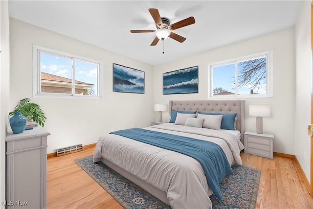 bedroom featuring visible vents, baseboards, ceiling fan, and light wood finished floors