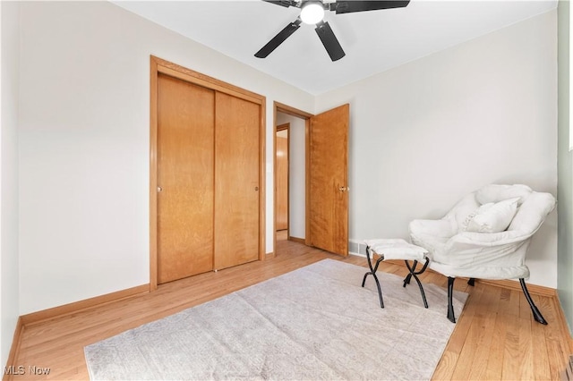 sitting room with visible vents, baseboards, and wood finished floors