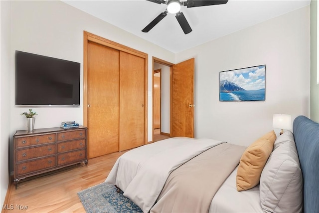 bedroom with a ceiling fan, a closet, and light wood finished floors