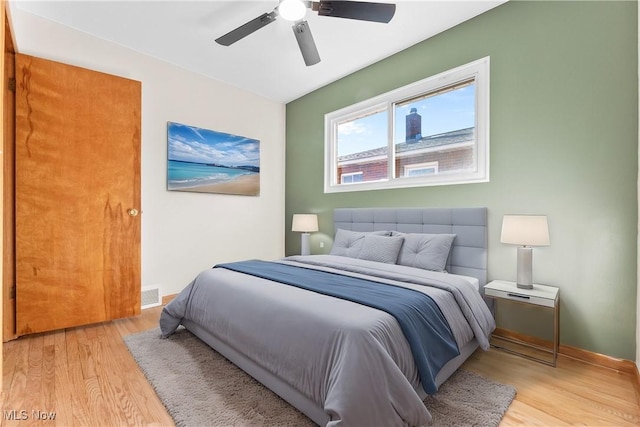 bedroom with visible vents, baseboards, ceiling fan, and light wood finished floors