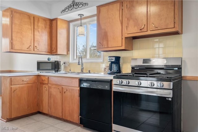 kitchen with decorative backsplash, appliances with stainless steel finishes, light countertops, and a sink