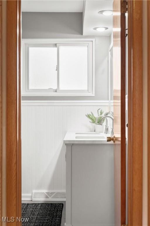 bathroom with vanity, visible vents, and a wealth of natural light