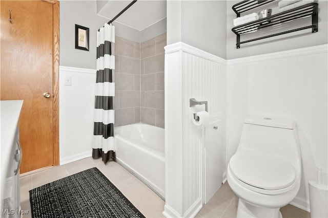 full bathroom featuring shower / bath combo with shower curtain, toilet, wainscoting, and tile patterned flooring