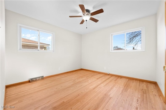 unfurnished room with visible vents, ceiling fan, light wood-type flooring, and baseboards